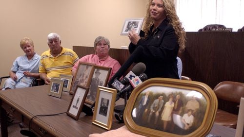 030502 - ATLANTA, GA -- As family members of the Alday's address the press after a parole board clemency hearing for Carl Isaacs who was convicted for the 1973 murders of six Aldays. A rendering of the six Alday's killed is displayed in the foreground. (Special/ JOHN AMIS) 