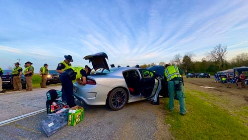 Police along I-16 in Twiggs County searching a car last weekend during the annual St. Patrick's Day license check and sobriety checkpoint they set up at an exit southeast of Macon. (Joe Kovac Jr. / joe.kovac@ajc.com)
