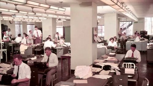 Reporters crank out copy in 1950 in the Atlanta Constitution newsroom. Longtime reporter/columnist Celestine Sibley composes something, mid-right of photo. (credit: AJC archives)
