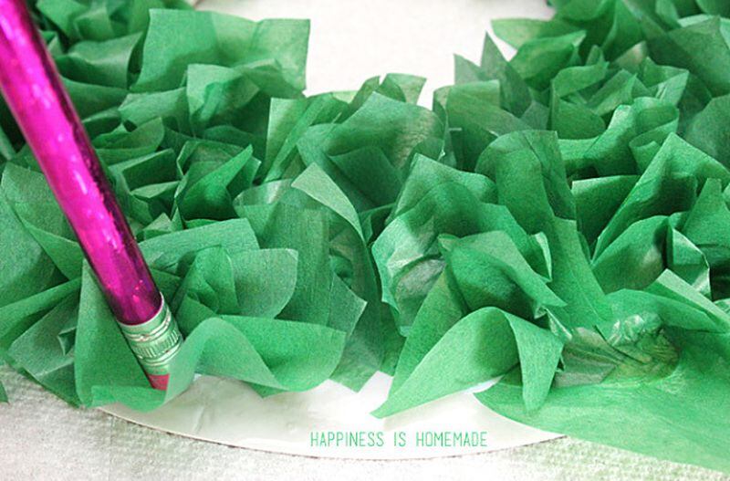Using the eraser end of a pencil helps shape the tissue paper squares used to make wreaths.