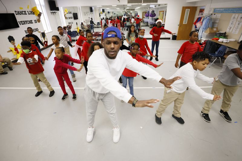 Dance teacher Cameron Davis helps second-grader students with some dance instructions on Tuesday, Dec. 13, 2022. Utopian Academy is partnering with Trilith Studios, the home of Marvel and D.C. blockbusters, in teaching young children about the world of film and TV.
 Miguel Martinez / miguel.martinezjimenez@ajc.com