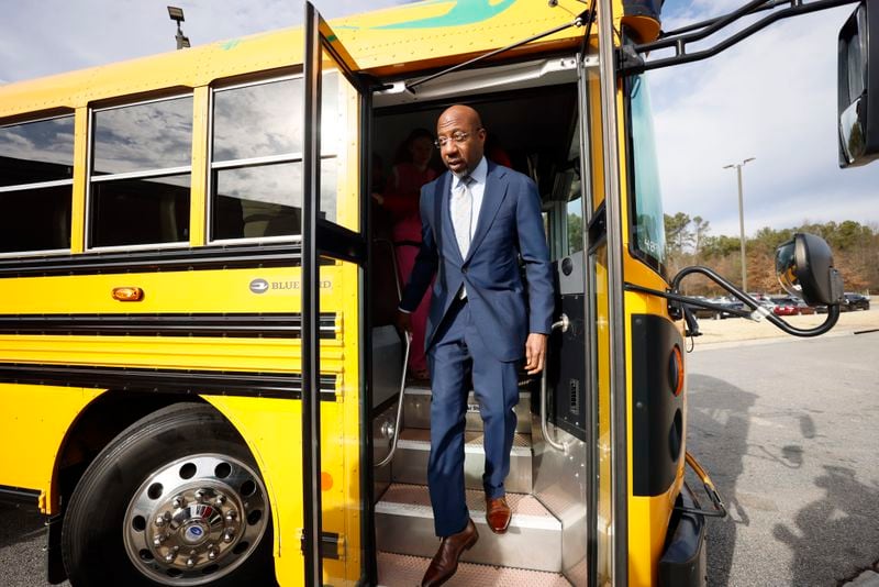 After a test ride on an electric bus, U.S. Sen. Raphael Warnock, D-Ga., exits at Stone Mountain Middle School on Monday, Jan. 8, 2024. The DeKalb County School District received a $20 million grant from the Environmental Protection Agency to purchase electric buses. (Miguel Martinez /miguel.martinezjimenez@ajc.com)