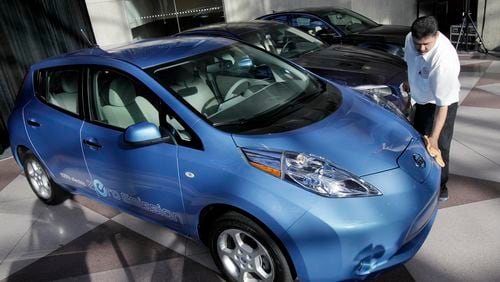 A worker dusts a Nissan Leaf before it was announced as the 2011 World Car of the Year at the New York International Auto Show. credit: Associated Press A Nissan Leaf/AP file