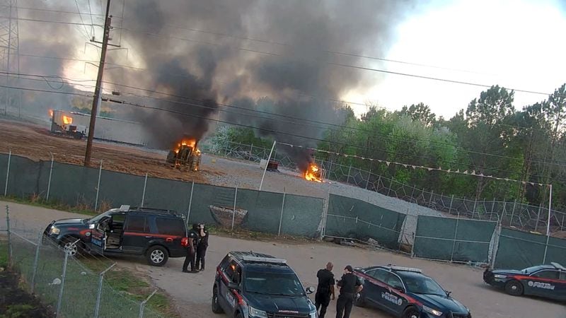A photo provided by the Atlanta Police Department shows vehicles burning after hundreds of activists breached the site of a proposed police and fire training center in Atlanta’s wooded outskirts on Sunday, March 5, 2023, burning police and construction vehicles and a trailer, and setting off fireworks toward officers stationed nearby. The destruction occurred on the second day of what is supposed to be a weeklong series of demonstrations to protest the building of the Atlanta Public Safety Training Center, a planned 85-acre campus owned by the city and derivisely called Cop City by opponents. (City of Atlanta Police Department via The New York Times) — NO SALES; EDITORIAL USE ONLY—