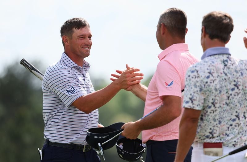 Bryson DeChambeau (left) greets fellow golfers after finishing his first round at the Masters.
