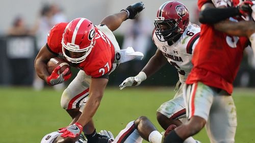 Georgia tailback Nick Chubb goes over South Carolina defender Skai Moore for extra yardage in the second half on the way to a 24-10 victory and a 9-0 record in a NCAA college football game on Saturday, November 4, 2017, in Athens.    Curtis Compton/ccompton@ajc.com