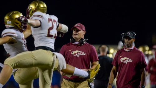 Brookwood head coach Philip Jones (middle) watches his player react to a touchdown in the second half of Friday's game against Walton. (Daniel Varnado/Special to the AJC)