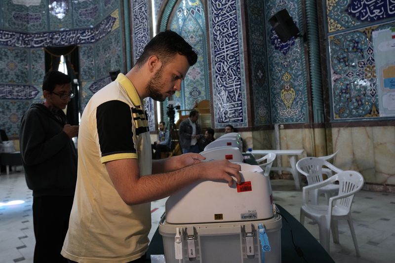 An Iranian man votes for the parliamentary runoff elections at a polling station in Tehran, Iran, Friday, May 10, 2024. Iranians voted Friday in a runoff election for the remaining seats in the country's parliament after hard-line politicians dominated March balloting. (AP Photo/Vahid Salemi)