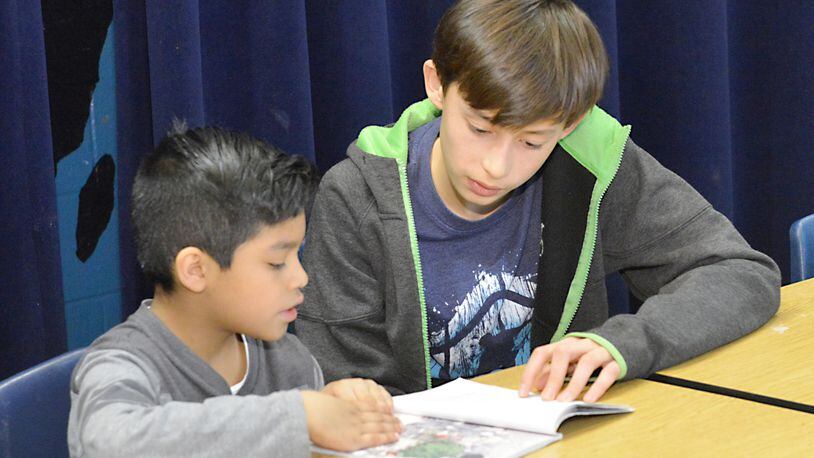High Meadows student Lucas Patsy (right) works with a youngster in the Star House after-school support program at Mimosa Elementary in Roswell. Eighth graders from High Meadows have been working as peer tutors for four years.