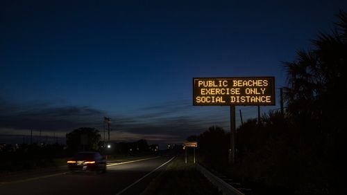A GDOT sign, along the causeway to Tybee Island, informs motorists of Gov. Bryan Kemp’s executive order, allowing people to access the state’s beaches for exercise, with social distancing of at least 6 feet. Kemp’s statewide order supersedes local shelter-in-place mandates. (AJC Photo/Stephen B. Morton)