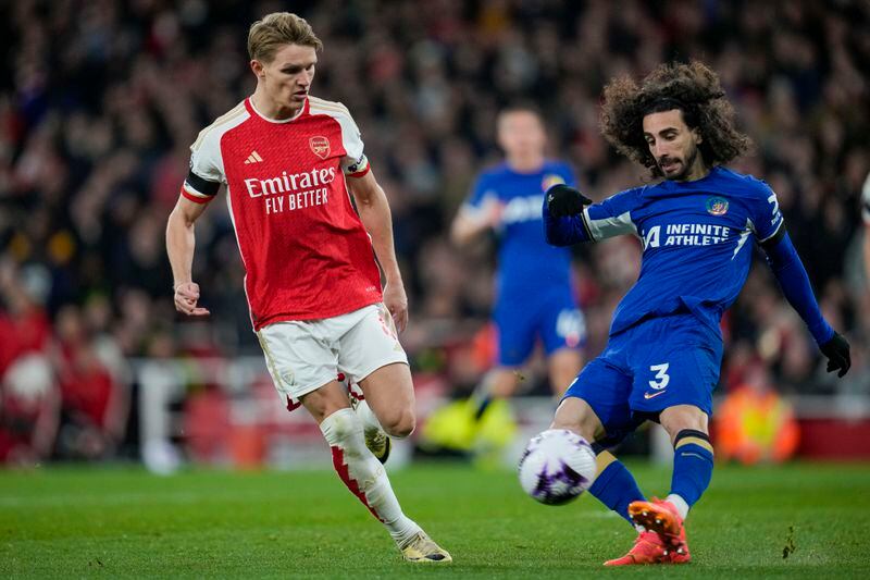 Arsenal's Martin Odegaard, left, tries to block a shot from Chelsea's Marc Cucurella during the English Premier League soccer match between Arsenal and Chelsea at Emirates Stadium in London, Tuesday, April 23, 2024. (AP Photo/Kin Cheung)