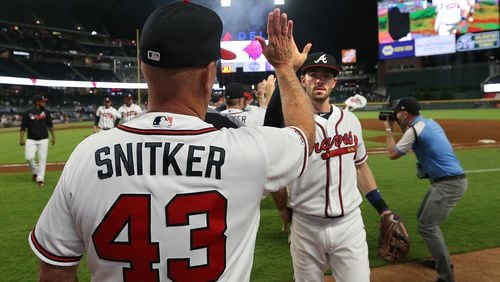 Braves manager Brian Snitker gives Dansby Swanson five after a 5-1 victory over the San Diego Padres on Wednesday, May 1, 2019, in Atlanta.