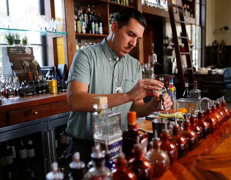  Miles Macquarrie mixes classic cocktails at the Kimball House in Decatur. / AJC file photo