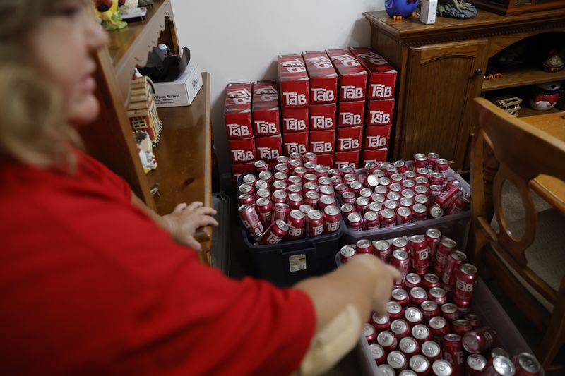 Andrea Ybarbo points to her stash of Tab soda at her home in Mableton on Tuesday, Nov. 21, 2023. Since Coca Cola announced they were discontinuing the diet drink in 2020, Ybarbo went on a search to amass as many cans as possible before they dissipated from the shelves.  (Natrice Miller/ Natrice.miller@ajc.com)