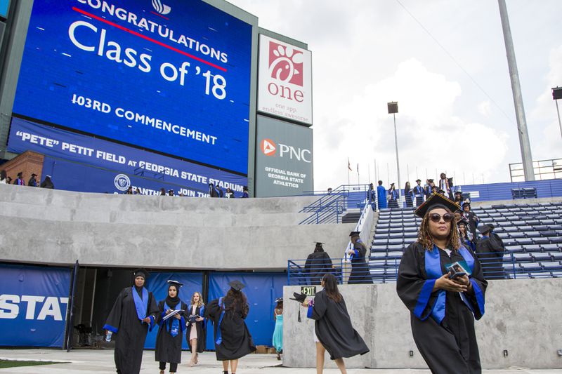 After Parker “Pete” Petit donated $10 million to Georgia State University’s athletic program, the school’s new football field was named for him. In this photo, undergraduate students enter the field for a commencement ceremony in May. REANN HUBER / REANN.HUBER@AJC.COM