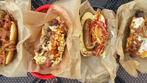 DBA is a barbecue mainstay, but it also offers quarter-pound beef frankfurters. Pictured from left are the stew dog, Mac Daddy, andouille dog and DBA dog. Ligaya Figueras/ligaya.figueras@ajc.com
