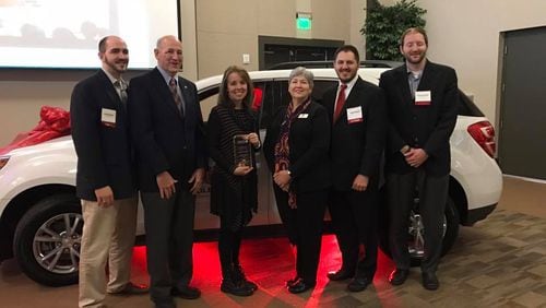 Forsyth county teacher Maleah Stewart (pictured with plaque) poses with school district officials after winning 2017 teacher of the year honors.