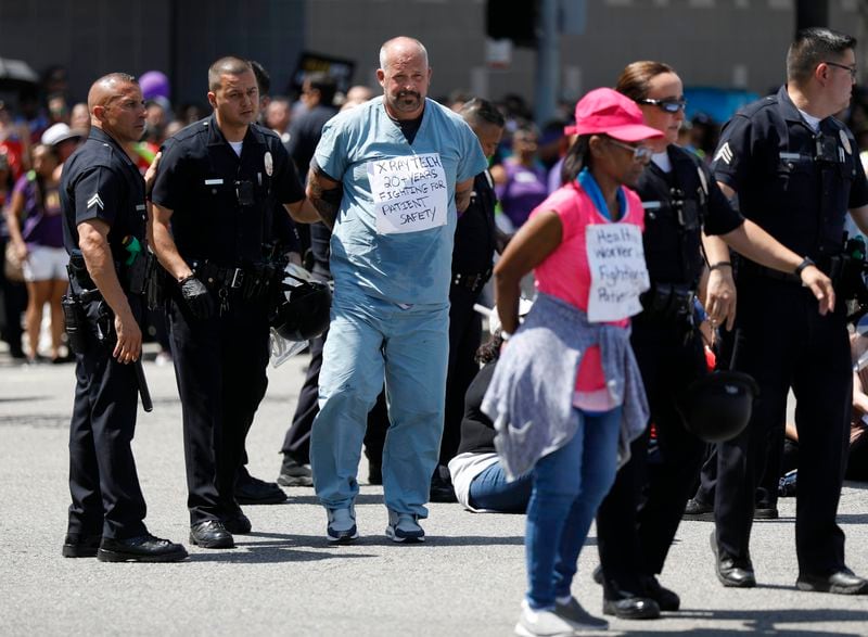 Los Angeles police officers arrest demonstrators while Kaiser Permanente workers, along with patients, clergy, elected leaders and community allies, hold a protest against the health care giant in Los Angeles on Sept. 2, 2019. (Gary Coronado/Los Angeles Times/TNS)