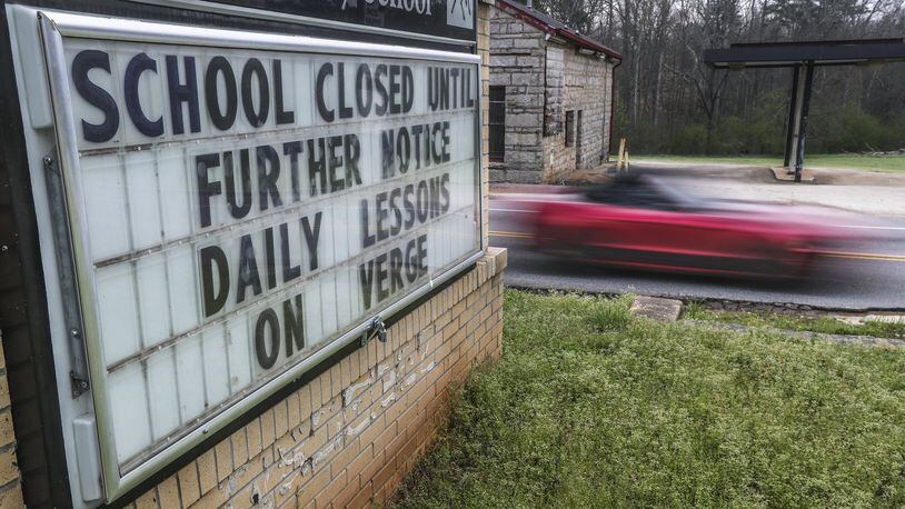 A sign posted in March outside the Murphey Candler Elementary School in DeKalb County announces the school building closures prompted by the coronavirus and the move to at-home learning. JOHN SPINK/AJC FILE PHOTO