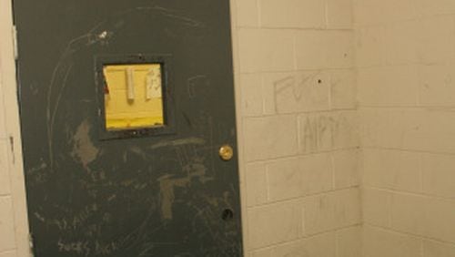 This metal door locked 13-year-old Jonathan King of Hall County into a seclusion room at one of Georgia’s “psychoeducational” programs for students with behavioral and emotional disabilities. Jonathan hanged himself in this room in 2004. (Photo by Gainesville Police Department.)