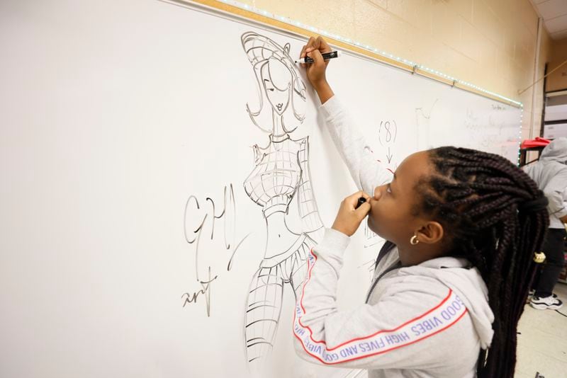 Fashion and design student Gavriell Leaks sketched a new idea at Utopian Academy on Tuesday, Dec. 13, 2022. Utopian Academy is partnering with Trilith Studios, the home of Marvel and D.C. blockbusters, in teaching young children about the world of film and TV.
 Miguel Martinez / miguel.martinezjimenez@ajc.com