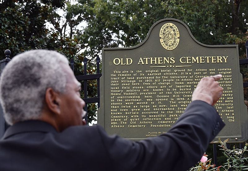 Fred Smith stands at a state historical marker on campus near the entrance to the Old Athens Cemetery near Baldwin Hall.