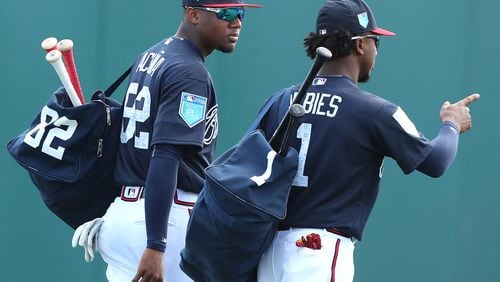 Ronald Acuna and Ozzie Albies head out with their gear early in spring training.