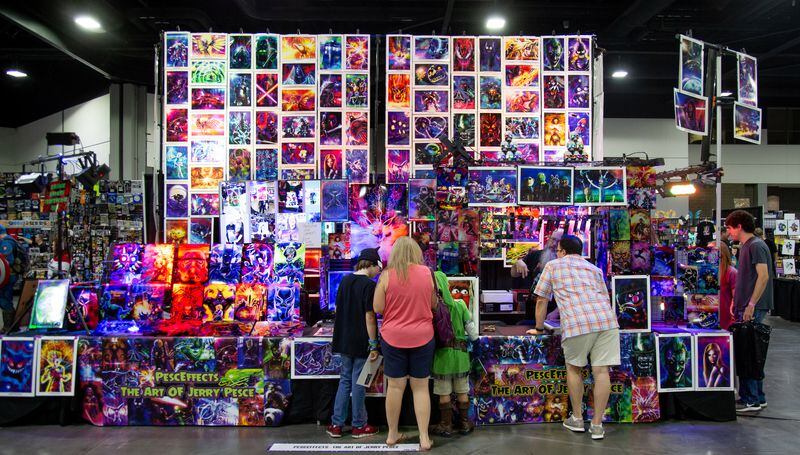 People gather around a vendor both of limited edition metal prints during the Atlanta Comic Con Sunday, July 2018 in the Georgia World Congress Center. STEVE SCHAEFER / SPECIAL TO THE AJC