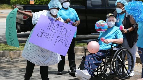 Workers celebrate during a family and community parade for residents and staff who have survived COVID-19 at Westbury Medical Care & Rehabilitation in Jackson, on May 13, 2020. Family members and supporters decorated vehicles with signs and posters and for many it was the first opportunity to see loved ones in months. Curtis Compton ccompton@ajc.com