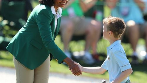 Carter Kontur, of Lawrenceville, is greeted by former Secretary of State (and Augusta National Golf Club member) Condoleezza Rice after putting on the 18th green during the Drive Chip & Putt National Finals at Augusta National Golf Club on Sunday, April 2. (Curtis Compton/ccompton@ajc.com)