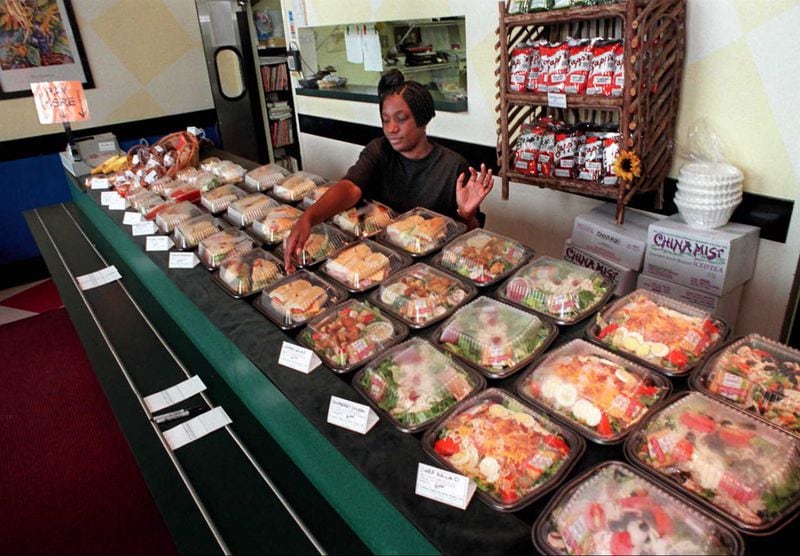 Counter person Wendy Harrington puts out boxed sandwiches and salads for lunchtime diners at Bona-Petite Cafe. They put away their menus and opted for boxed lunches for the 1996 Olympics. (AJC file photo)