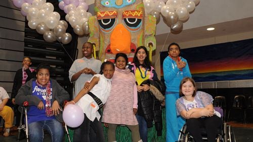 Several East Cobb Middle School students take a parting shot with the tiki display at the Adaptive PE Dance at Kennesaw Mountain High School in 2012.