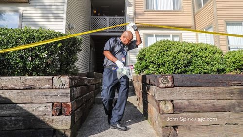 A Gwinnett police investigator gathers evidence at an apartment off Satellite Boulevard after a woman was killed in a domestic shooting Tuesday morning.