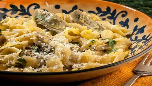 Baby artichokes get a generous dusting of grated Romano cheese in this pasta dish, enriched with cream and enlivened by fresh lemon.   (Bill Hogan/Chicago Tribune/TNS)