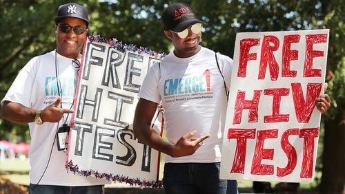 Reggie McKenzie (left) and Jamie Allen encourage attendees to get a free AIDS test during the Pure Heat Community Festival, part of Black Gay Pride weekend, at Piedmont Park on Sunday, Sept. 4, 2016, in Atlanta. Curtis Compton /ccompton@ajc.com AJC File Photo