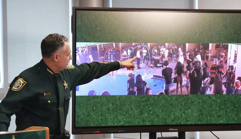During a press conference in Sanford, Fla., Monday, April 29, 2024, Seminole County Sheriff Dennis Lemma points out NFL Houston Texans wide receiver Tank Dell in a surveillance photo taken Sunday at the Cabana Live nightclub in Sanford, Fla., moments before shots were fired by two gunmen (in red circles.) Multiple patrons in the club, including Dell, were wounded by the gunfire. (Joe Burbank/Orlando Sentinel via AP)