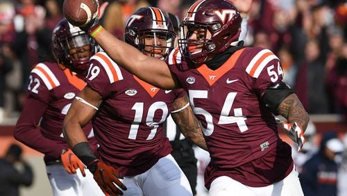 Linebacker Andrew Motuapuaka (54) of the Virginia Tech Hokies celebrates his interception against the Virginia Cavaliers with defensive back Chuck Clark (19) in the second half at Lane Stadium on November 26, 2016 in Blacksburg, Virginia. Virginia Tech defeated Virginia 52-10. (Photo by Michael Shroyer/Getty Images)