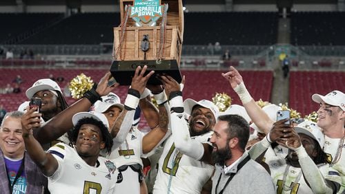 Gasparilla Bowl champions: Georgia Tech players hold the trophy after defeating Central Florida 30-17 in the Gasparilla Bowl Friday in Tampa.