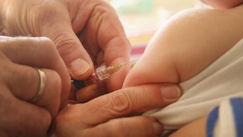 A children's doctor injects a vaccine against measles, rubella, mumps and chicken pox into an infant.