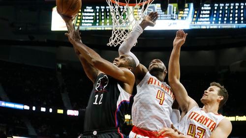 LA Clippers forward Luc Mbah a Moute (12) goes to the basket against Atlanta Hawks forward Paul Millsap (4) and forward Kris Humphries (43) in the first half of an NBA basketballgame Monday, Jan. 23, 2017, in Atlanta. (AP Photo/John Bazemore)