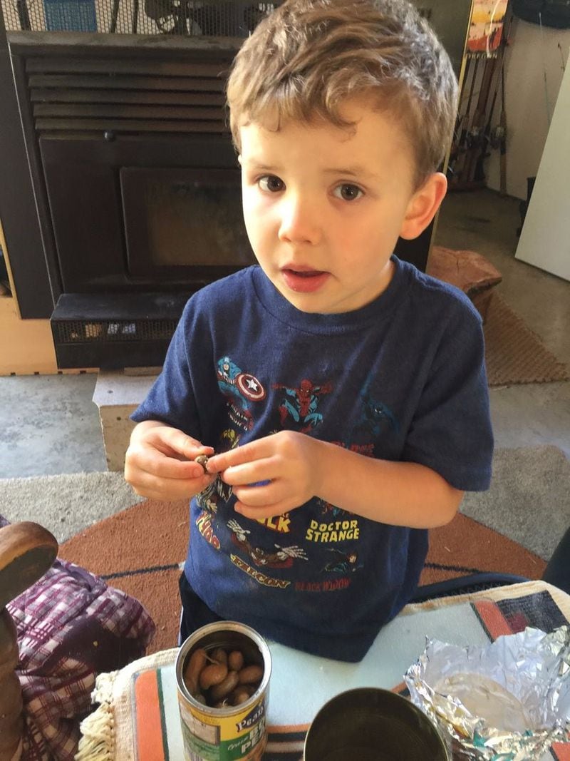 Austin Deen, 5, eats boiled peanuts given to him by his grandfather, Robert Deen. "He’s all Oregonian, but he loves the cans of boiled peanuts I keep in my workshop, said the older Deen, who recently wrote "The Boiled Peanut Book." CONTRIBUTED BY ROBERT DEEN