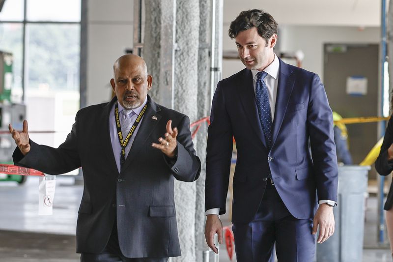 Hartsfield-Jackson International Airport General Manager Balram Bheodari (left) walks with Senator Jon Ossoff  (right) before a press conference on the expansion of Concourse D on Thursday, July 7, 2022 (Natrice Miller/natrice.miller@ajc.com)
