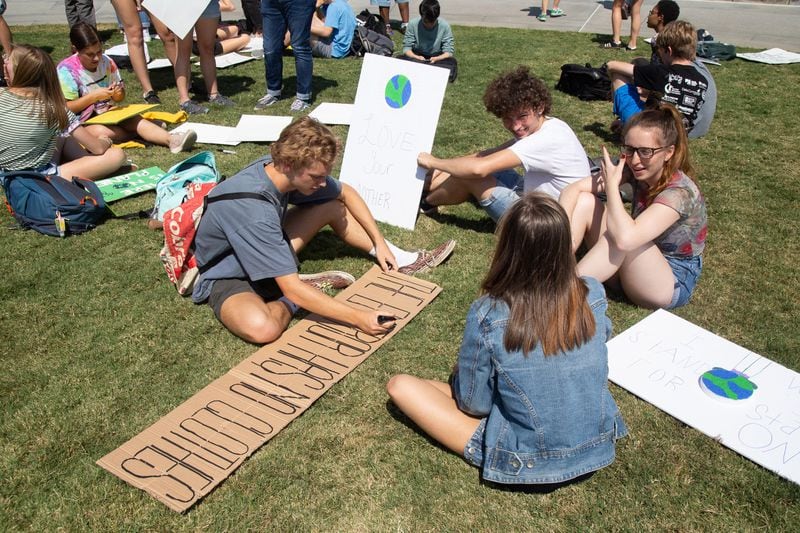 Students from Decatur High School work on signs at the Liberty Plaza before marching around the Capitol during the Climate Reality Strike March Friday, September 20, 2019. STEVE SCHAEFER / SPECIAL TO THE AJC