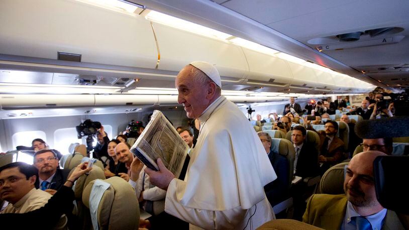 Pope Francis holds an image of Santa Teresa presented by a journalist as he leaves after his press conference on his flight from Sri Lanka to Manila, Philippines, Thursday, Jan. 15, 2015. (AP Photo/Alessandra Tarantino, Pool) Pope Francis made his comments aboard a plane flying to the Philippines. (AP Photo)