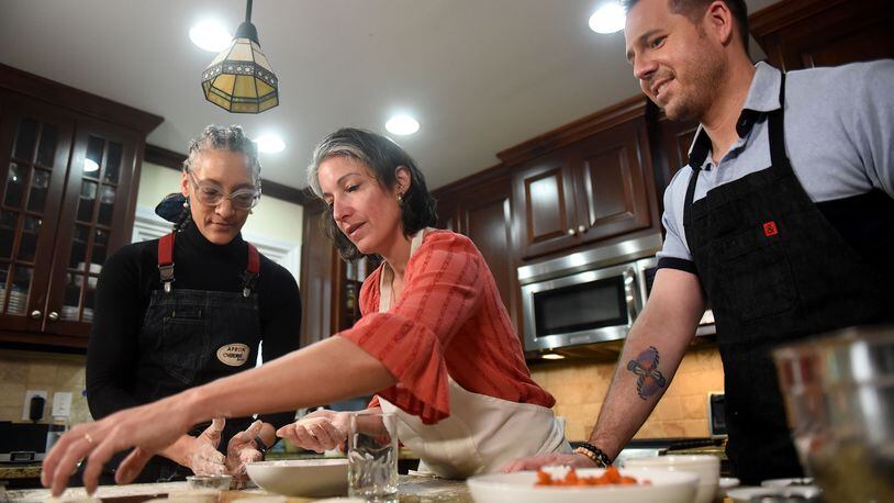 The AJC's Ligaya Figueras (center) hosts food expert Chadwick Boyd (right) and Top Chef Carla Hall (left) at her home, where the two share tips with Ligaya on how to make the best biscuits. RYON HORNE / RHORNE@AJC.COM