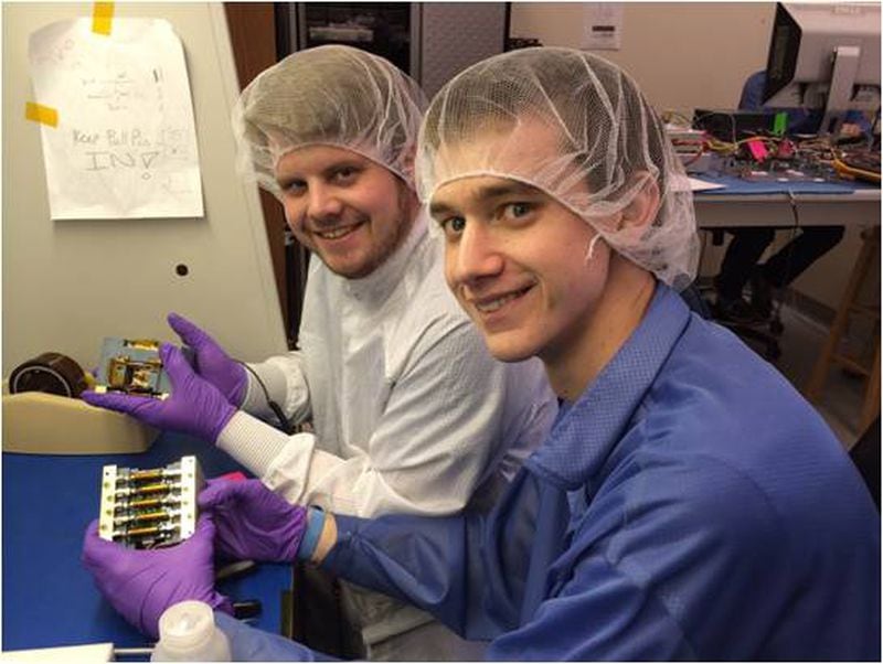 Georgia Tech graduate students Travis Imken (left) and Terry Stevenson (right) hold a propulsion system they designed and built that is similar to those that will be used on the NASA BioSentinel mission on Artemis 1.