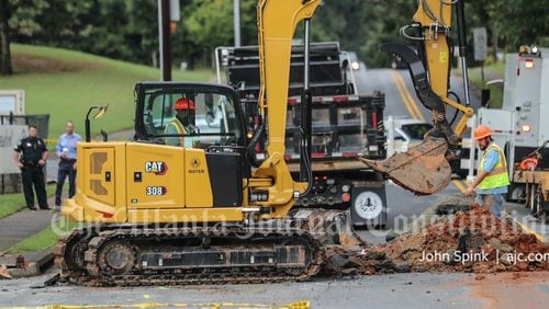 Cobb County water crews work to repair a break to a water main on Ben King Road that impacted 170 homes and two nearby elementary schools Wednesday morning.