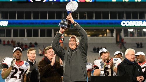 Head coach Mark Richt and the Georgia Bulldogs holds up the trophy after winning the Belk Bowl against the Louisville Cardinals at Bank of America Stadium on December 30, 2014 in Charlotte, North Carolina. Georgia won 37-14. (Photo by Grant Halverson/Getty Images)