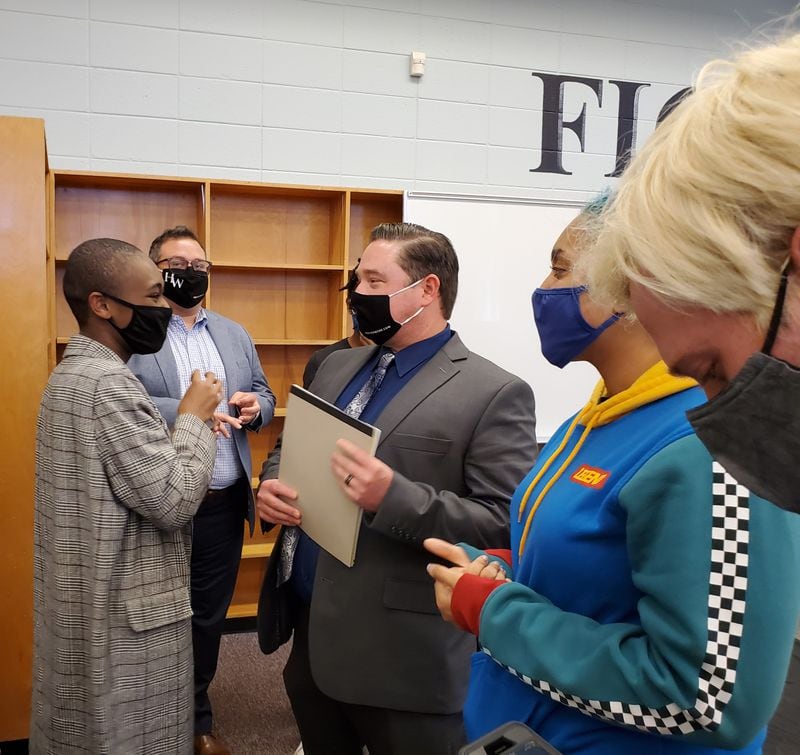 Spencer Jordan, center, speaks with his former student, Jahmina Santiago, after a panel overturned the Cobb school district's decision not to renew his contract. Credit: Kristal Dixon/The Atlanta Journal-Constitution