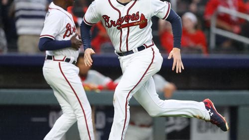 March 29, 2018 Atlanta: Atlanta Braves Freddie Freeman scores from second base on a wild pitch that advanced him to third and a errant throw to third sending him home during the eight inning against the Phillies in a MLB baseball home opening game on Thursday, March 29, 2018, in Atlanta.  Curtis Compton/ccompton@ajc.com